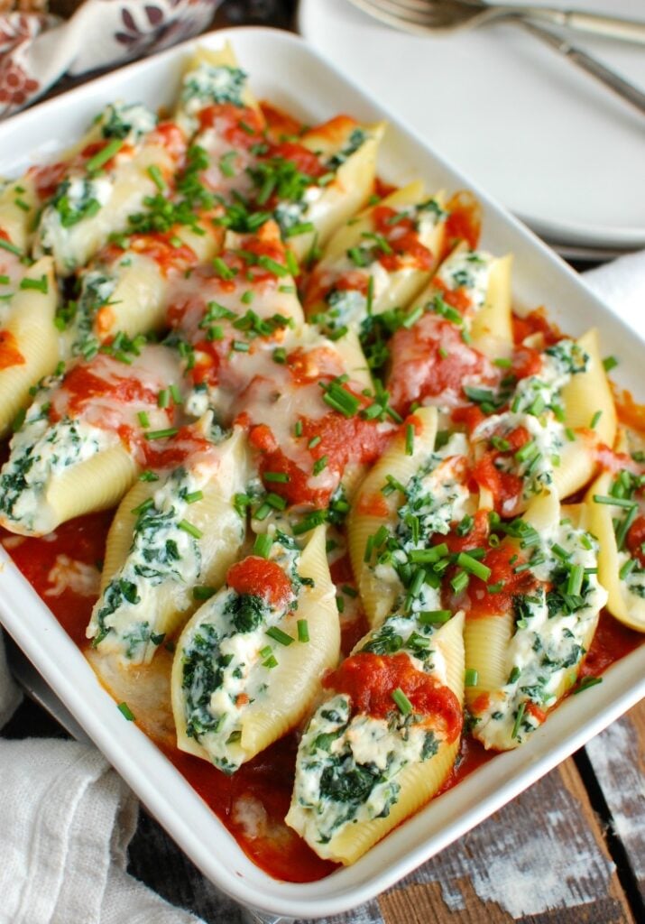 Stuffed Shells are a comforting, filling meal that makes the perfect meal for a large group. Large pasta shells are stuffed with a lemony-chive cheese mixture and topped with tomato sauce. They are baked to perfection and will warm you right up!