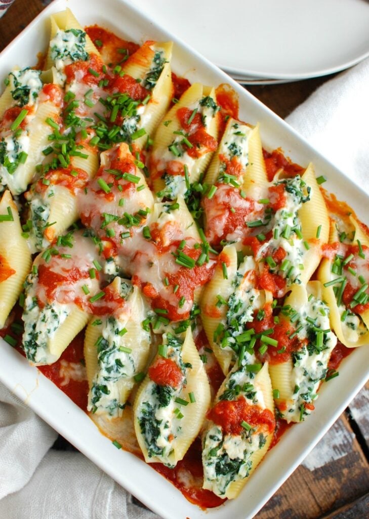 Stuffed Shells are a comforting, filling meal that makes the perfect meal for a large group. Large pasta shells are stuffed with a lemony-chive cheese mixture and topped with tomato sauce. They are baked to perfection and will warm you right up!