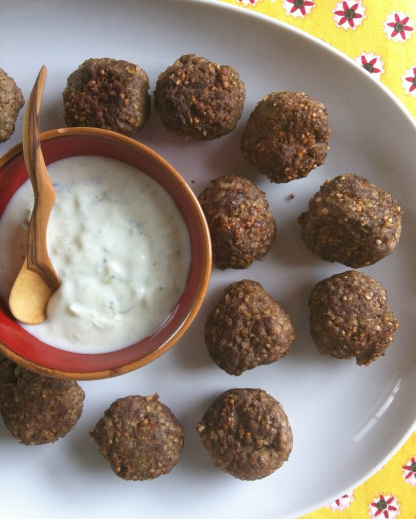 Kibbeh Meatballs With Spiced Yogurt Sauce is a delicious Lebanese appetizer or main dish recipe that’s traditionally made with ground lamb. These easy meatballs are made with beef, with Lebanese spices.