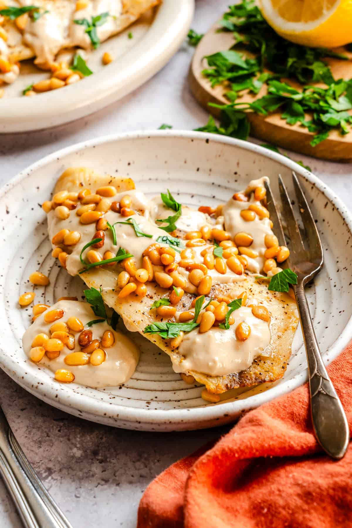 Easy Baked White Fish with Tahini Sauce on a white plate