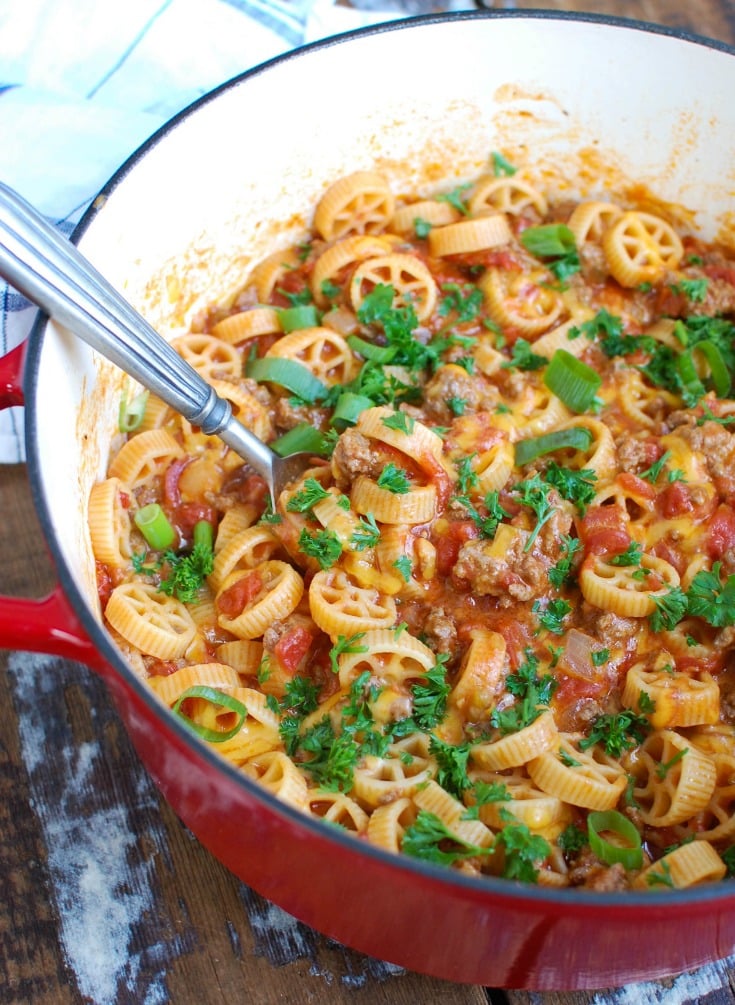 One Skillet Cheesy Hamburger Pasta is a quick and easy one skillet or pot meal mixing ground beef, tomatoes, cheese and pasta to create a cheesy hamburger dish.  The leftovers reheat wonderfully so you have options for lunch and dinner later in the week!