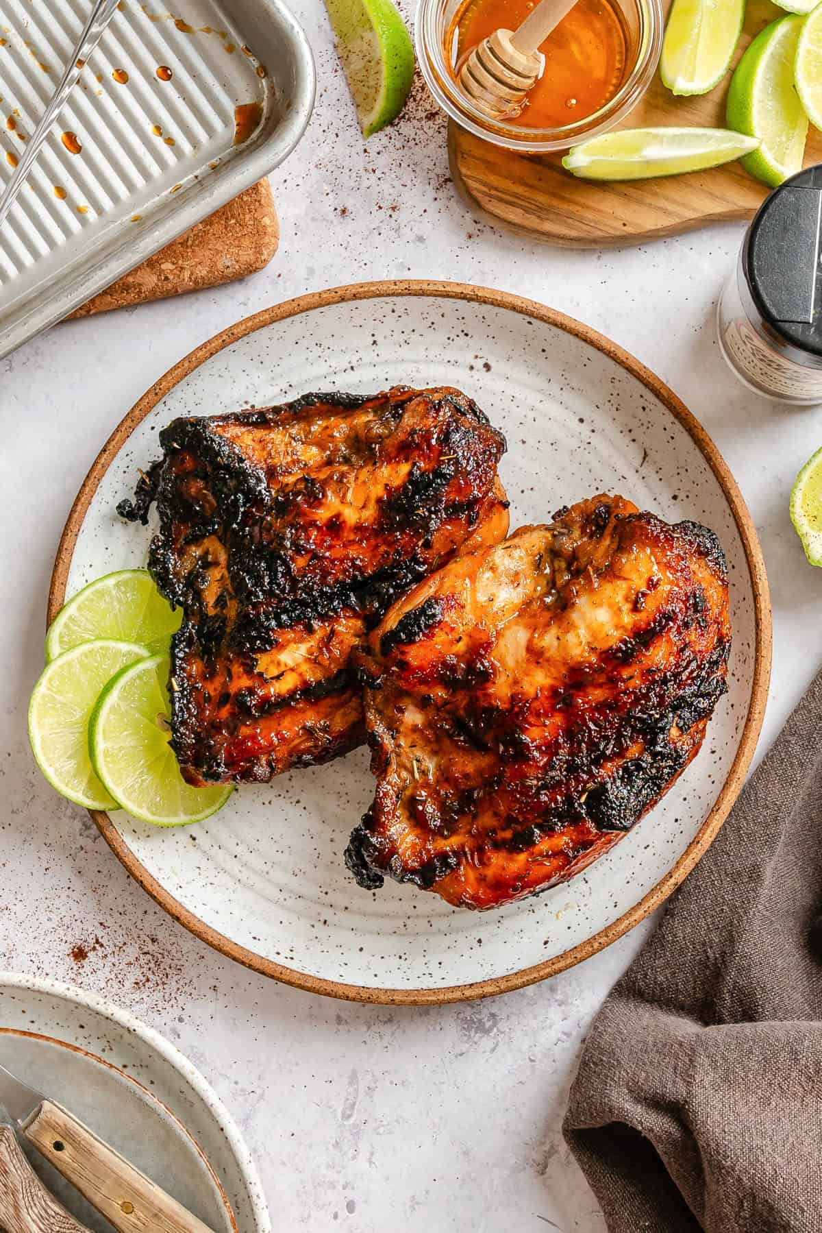 Spiced Lime Chicken on a white plate with limes