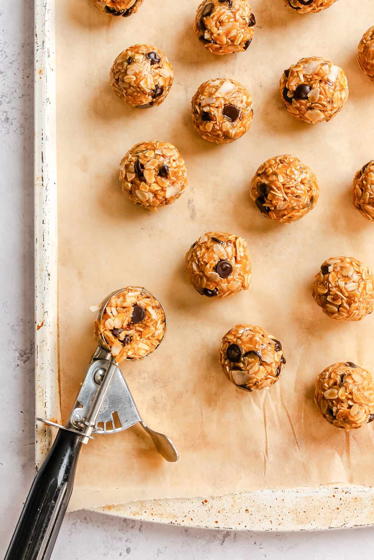 No-bake peanut butter oatmeal bites on a parchment-lined baking sheet ready to chill