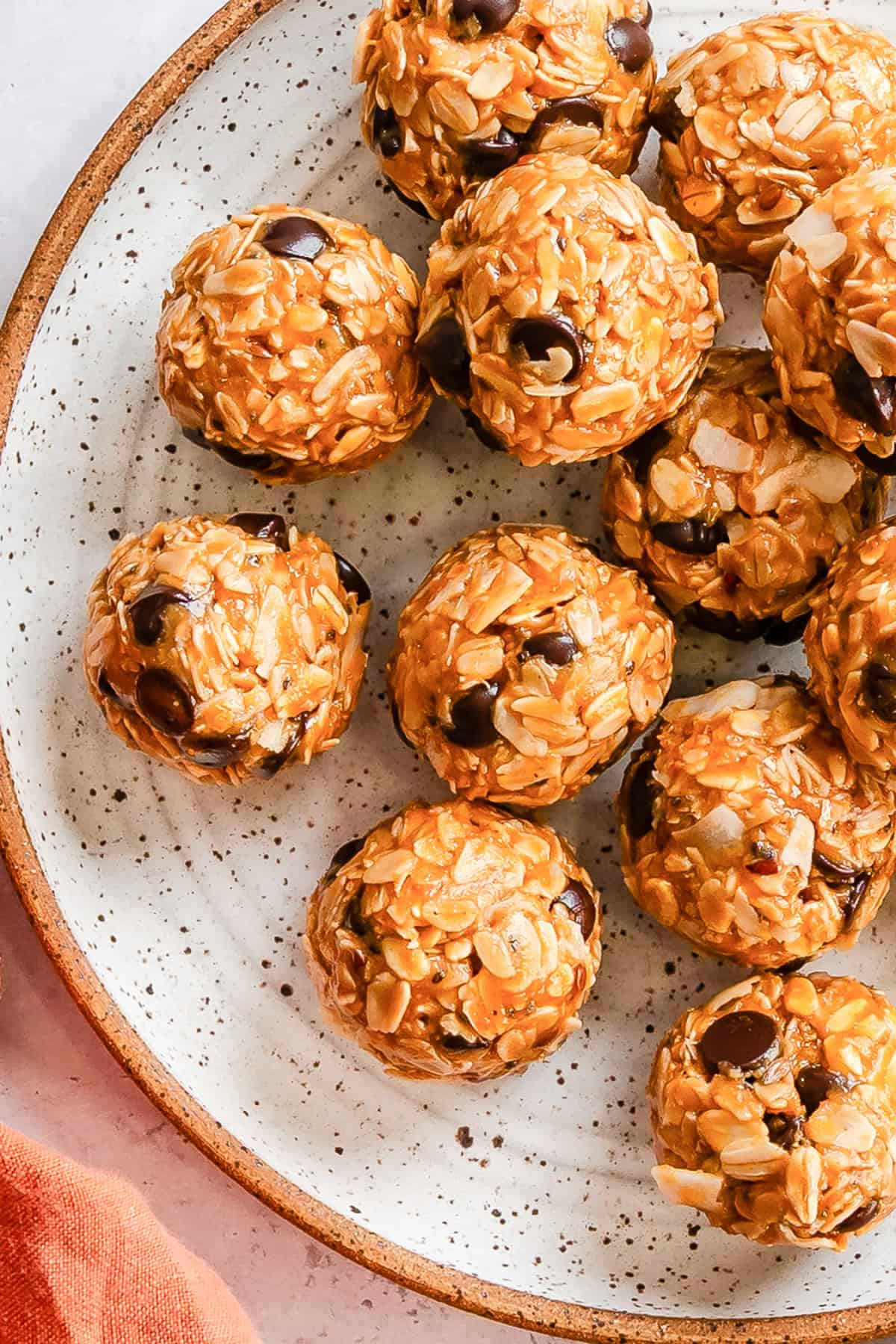 Peanut butter coconut oatmeal bites stacked in a white bowl showing chewy texture and chocolate chips