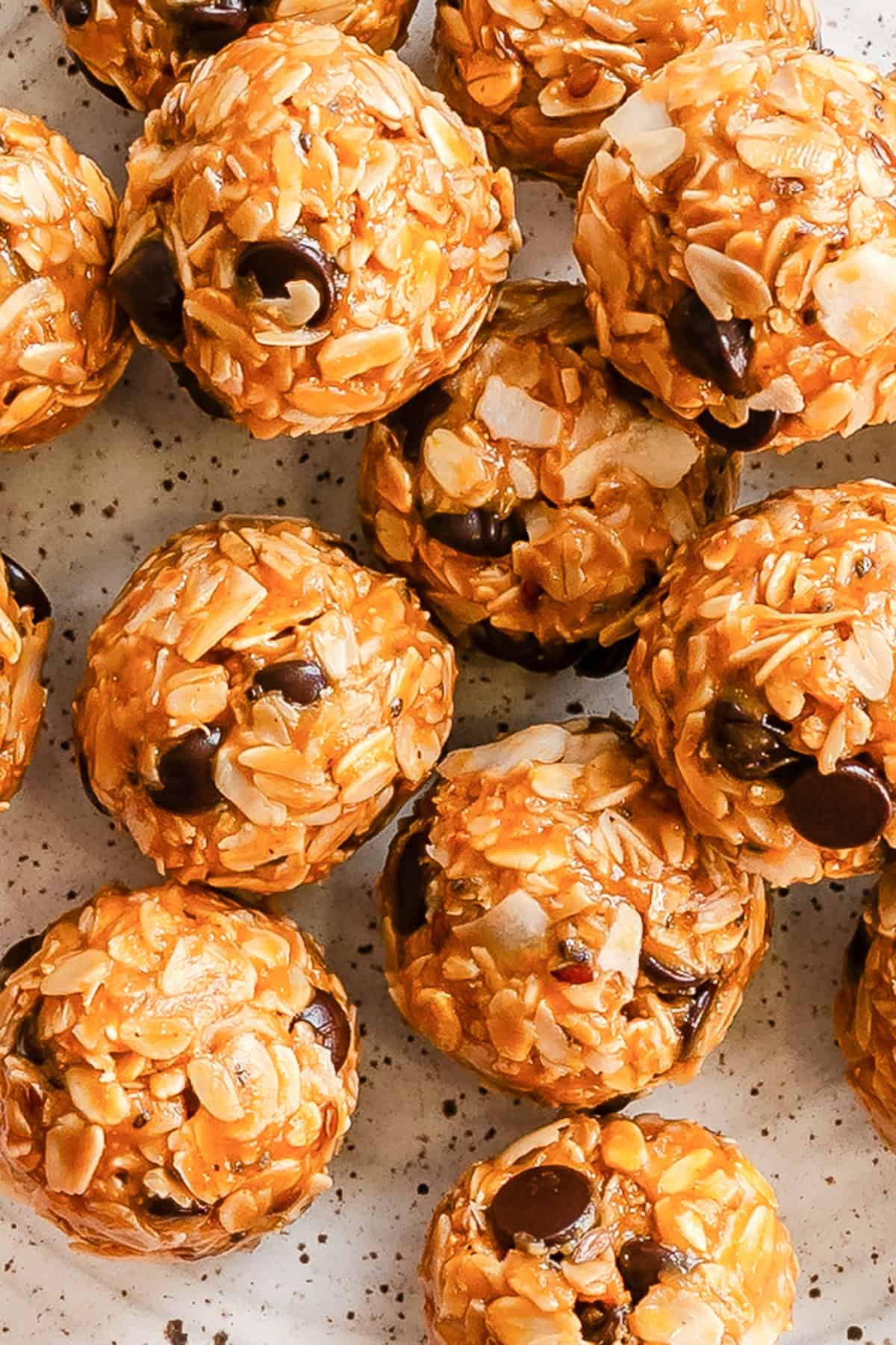 No-bake peanut butter coconut oatmeal bites arranged on a plate with chocolate chips and coconut flakes visible