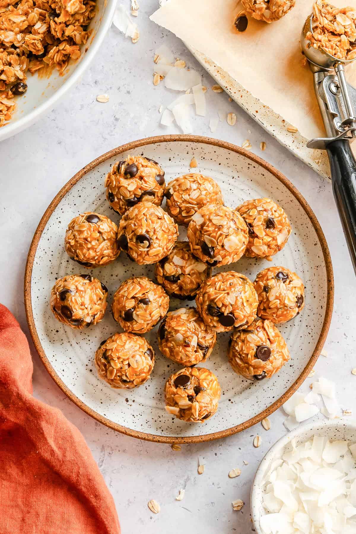 No-bake peanut butter coconut oatmeal bites arranged on a plate with chocolate chips and coconut flakes visible