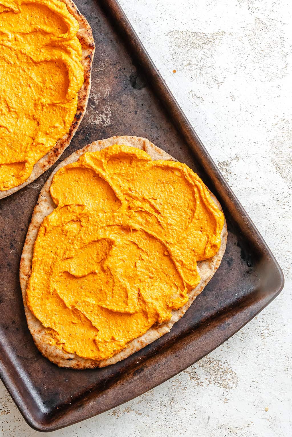 Mediterranean Naan Pizza with hummus on naan bread.