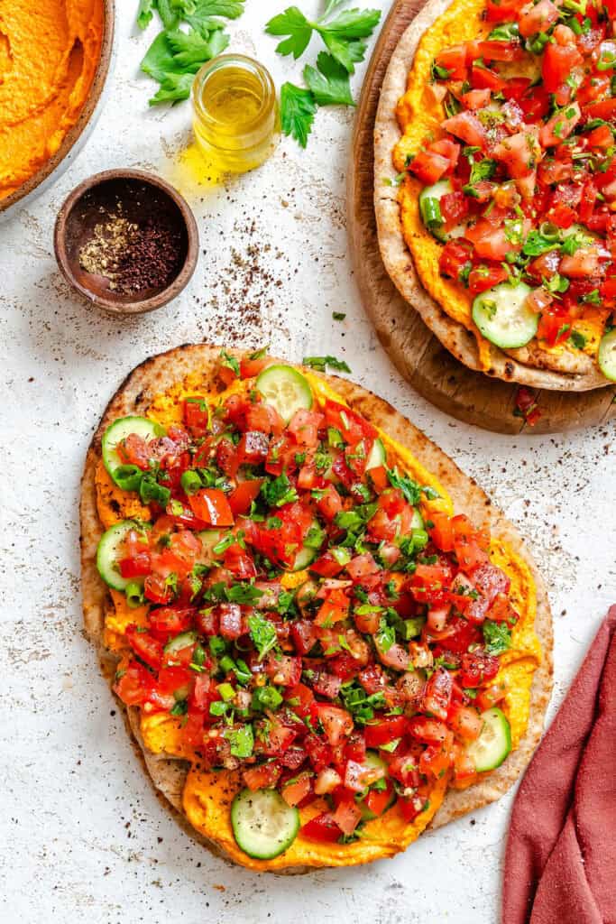Mediterranean Naan Pizza on a white cutting board with sumac 