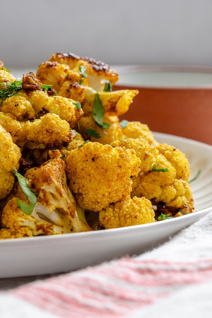 Curry Roasted Cauliflower up close on white plate 