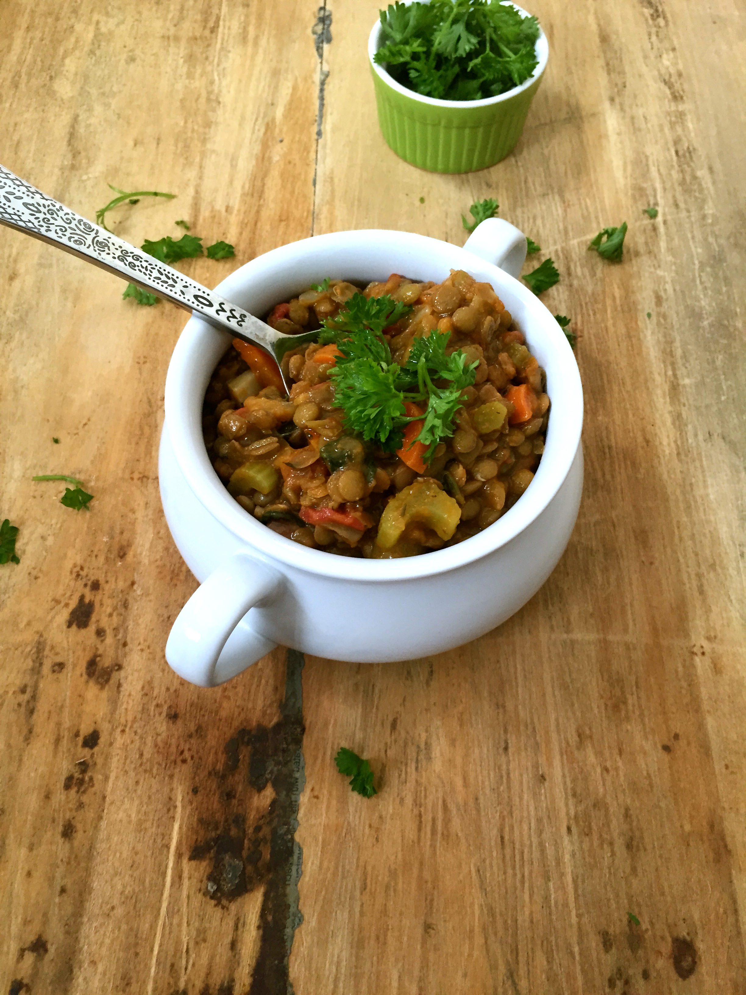 Green Lentil Spinach Soup with spoon in the soup.