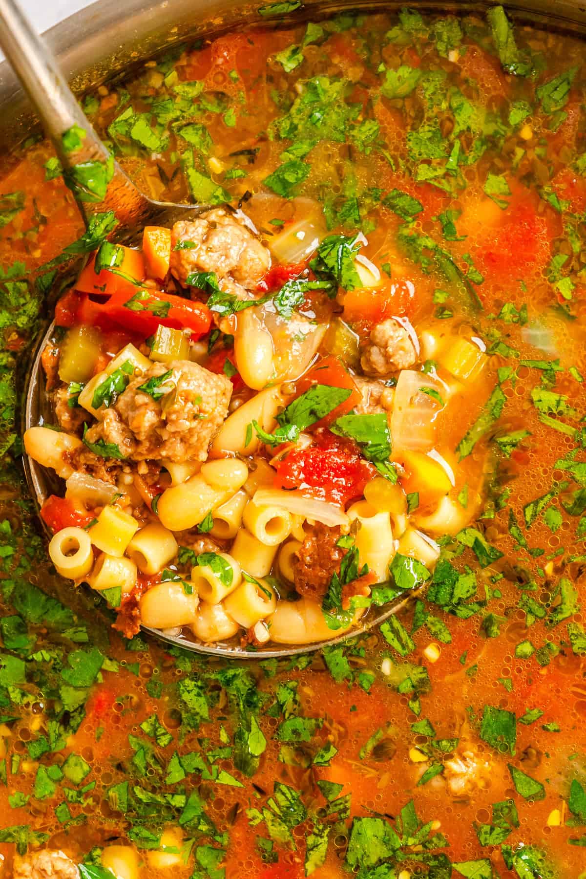Pasta e Fagioli in a dutch oven with a ladle scooping soup
