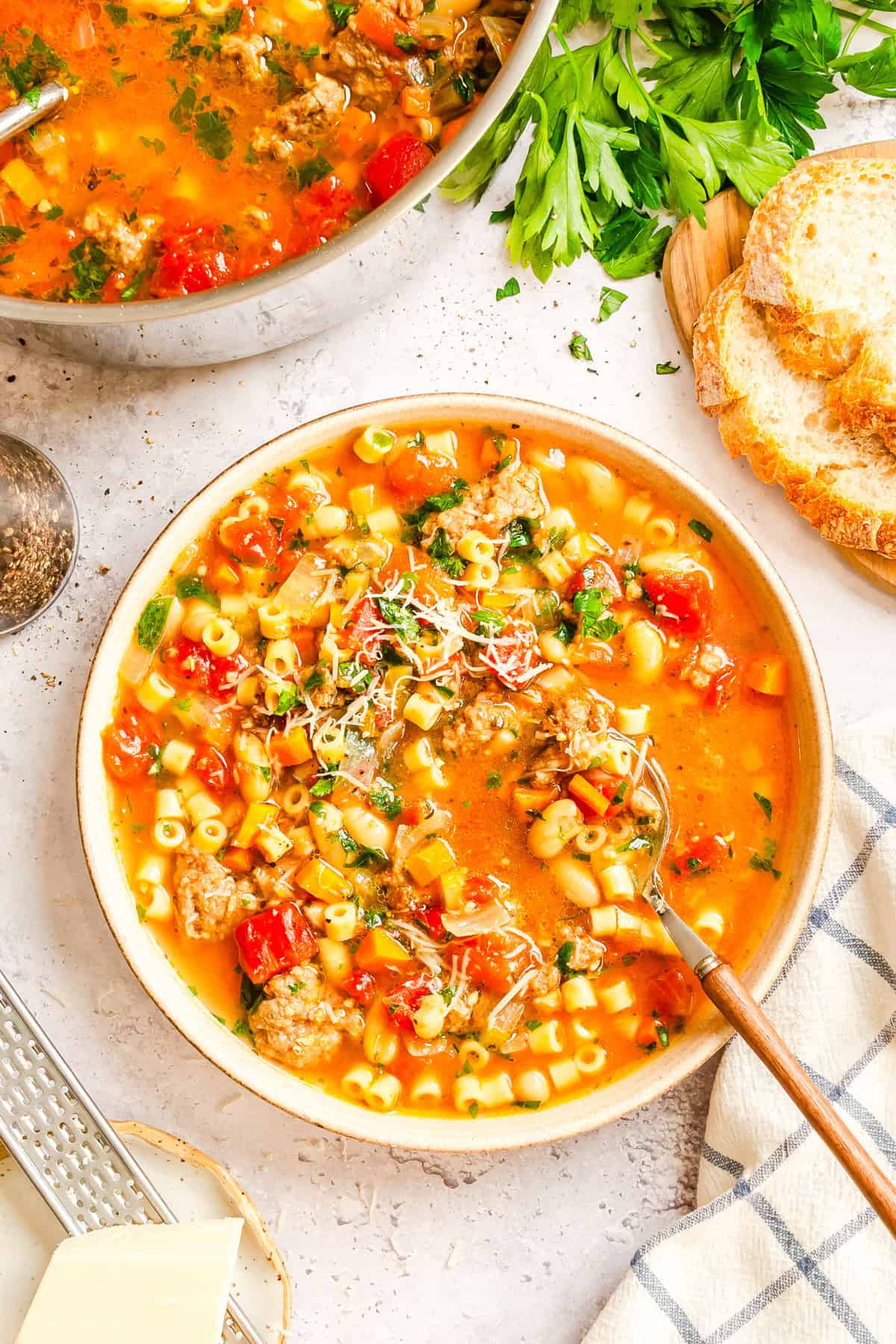 Close-up of thick, hearty pasta e fagioli soup showing tender beans, pasta, and ground beef in tomato broth