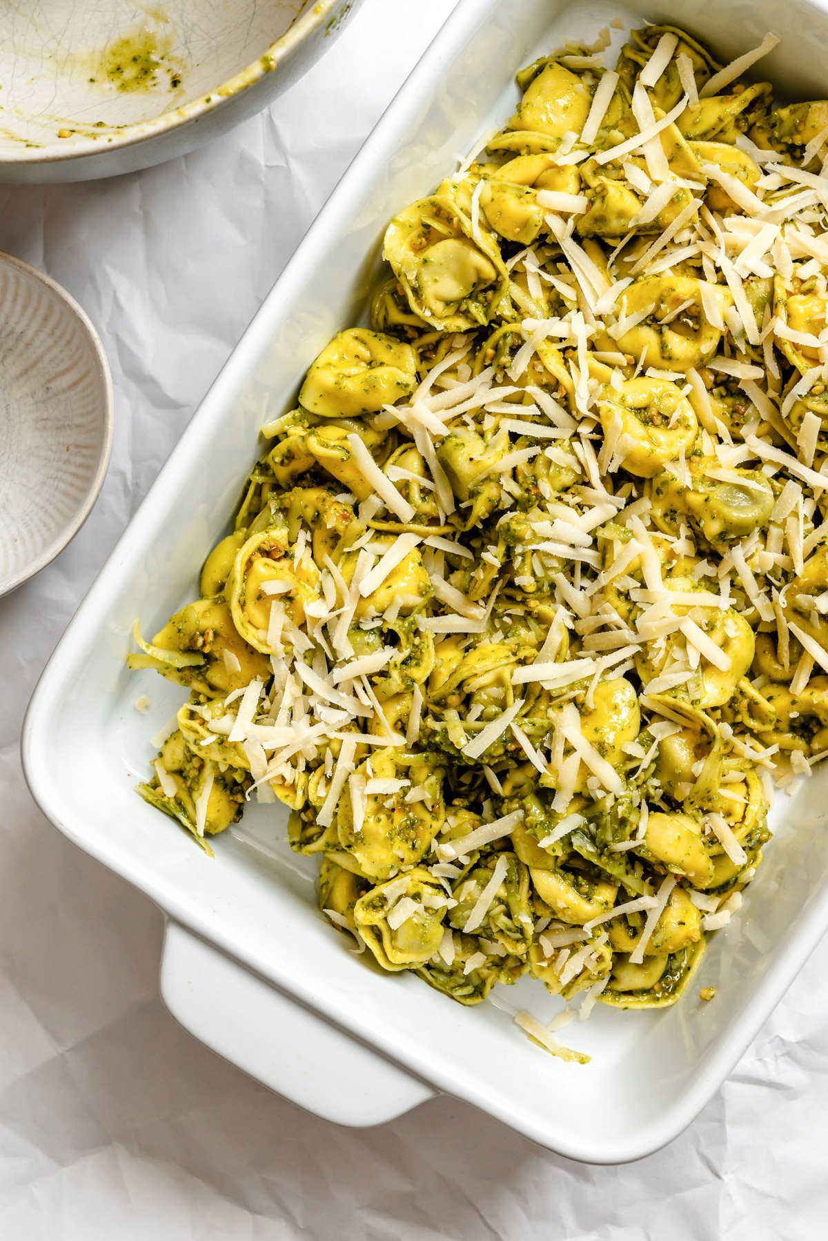 Pesto Tortellini in a baking dish with cheese 