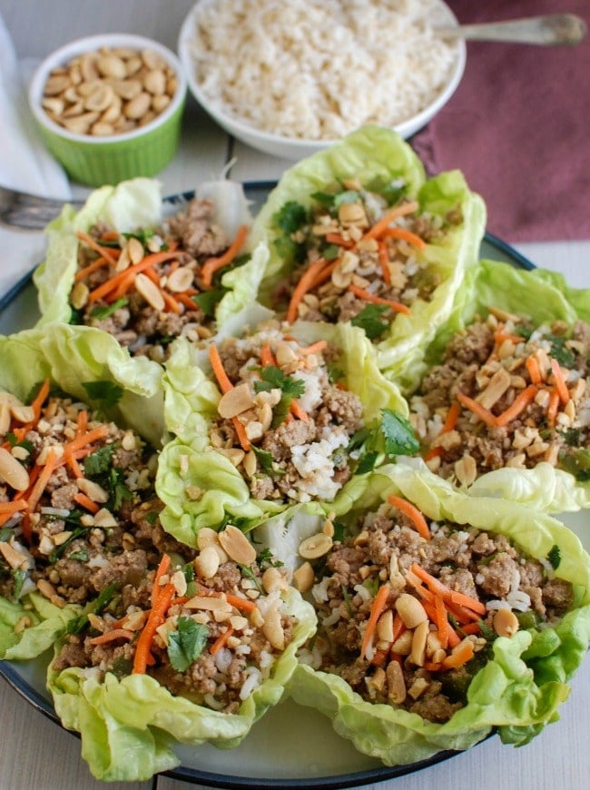 Thai Turkey Brown Rice Lettuce Wraps mix your favorite Asian flavors into a crisp, healthy lettuce wrap. Ground turkey is simmered in lime juice, ginger, soy sauce and red chili garlic sauce and mixed with brown rice. Top these with fresh cilantro, matchstick carrots and crunchy peanuts and you have a healthy meal. 