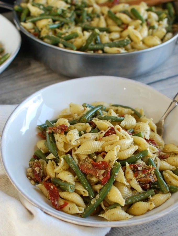 Pesto Pasta with Green Beans Sun-dried Tomatoes and Toasted Pine Nuts with spoon.