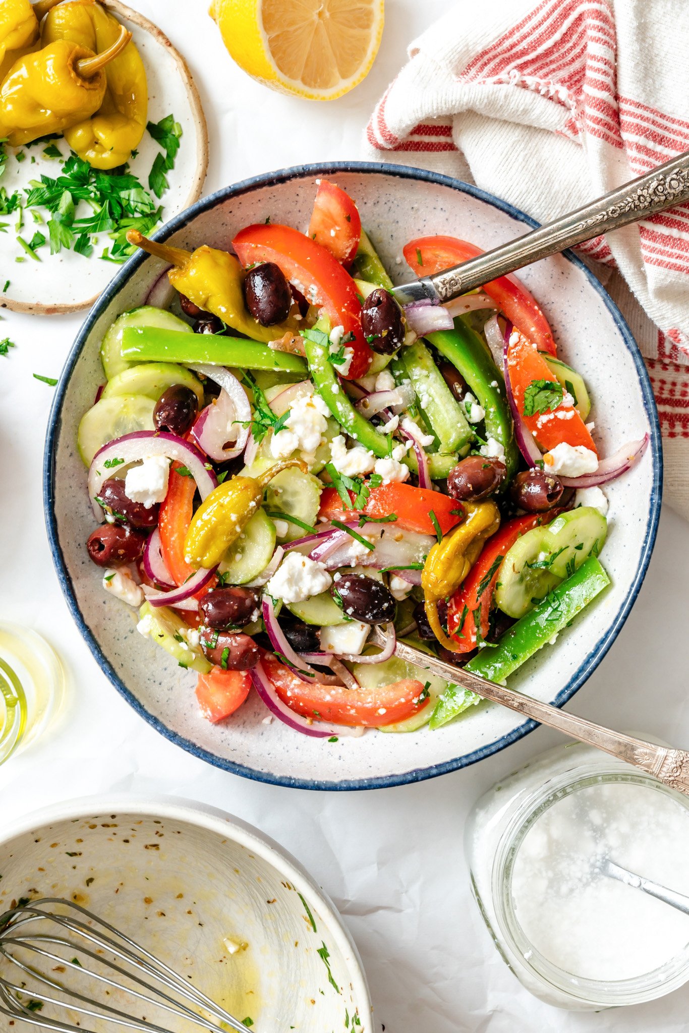 Greek village Salad  in a blue rimmed bowl with a fork
