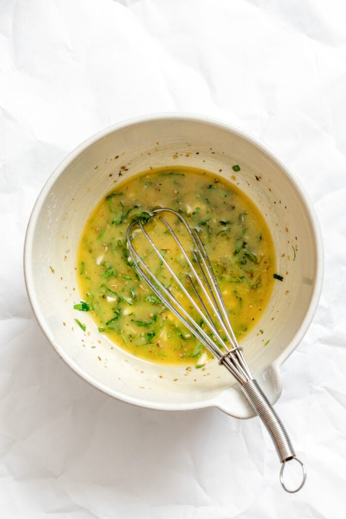 Greek Village Salad mixed dressing in a bowl