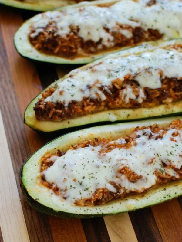 Mediterranean Zucchini Boats take summer zucchini and stuff them with a mixture of ground beef and lamb, rice, tomato sauce, cumin, cinnamon and are topped with cheese and fresh parsley. If you have an abundance of garden zucchini this is the perfect way to use them up!