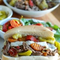 Slow Cooker Italian Beef Sandwiches make a great game day food or weeknight dinner that easily cooks in your crockpot. Chuck roast is slowly cooked in Italian seasonings, beef broth and mixed with pepperoncini peppers and Giardiniera. Toast the beef in a hoagie bun with provolone cheese and extra pepperoncini and Giardiniera for the perfect sandwich.