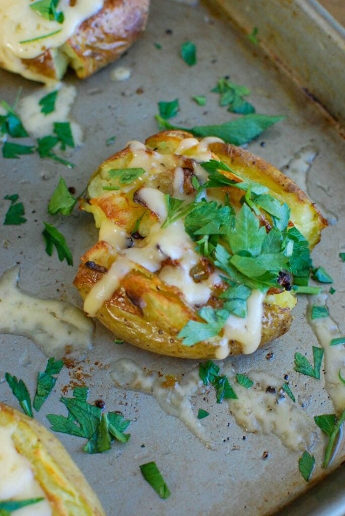 Golden potatoes are drizzled with olive oil and garlic and baked until crispy and then topped with gouda and warmed until the cheese is warm and melted. Gouda Smashed Potatoes are the perfect holiday side dish that will impress your guests.