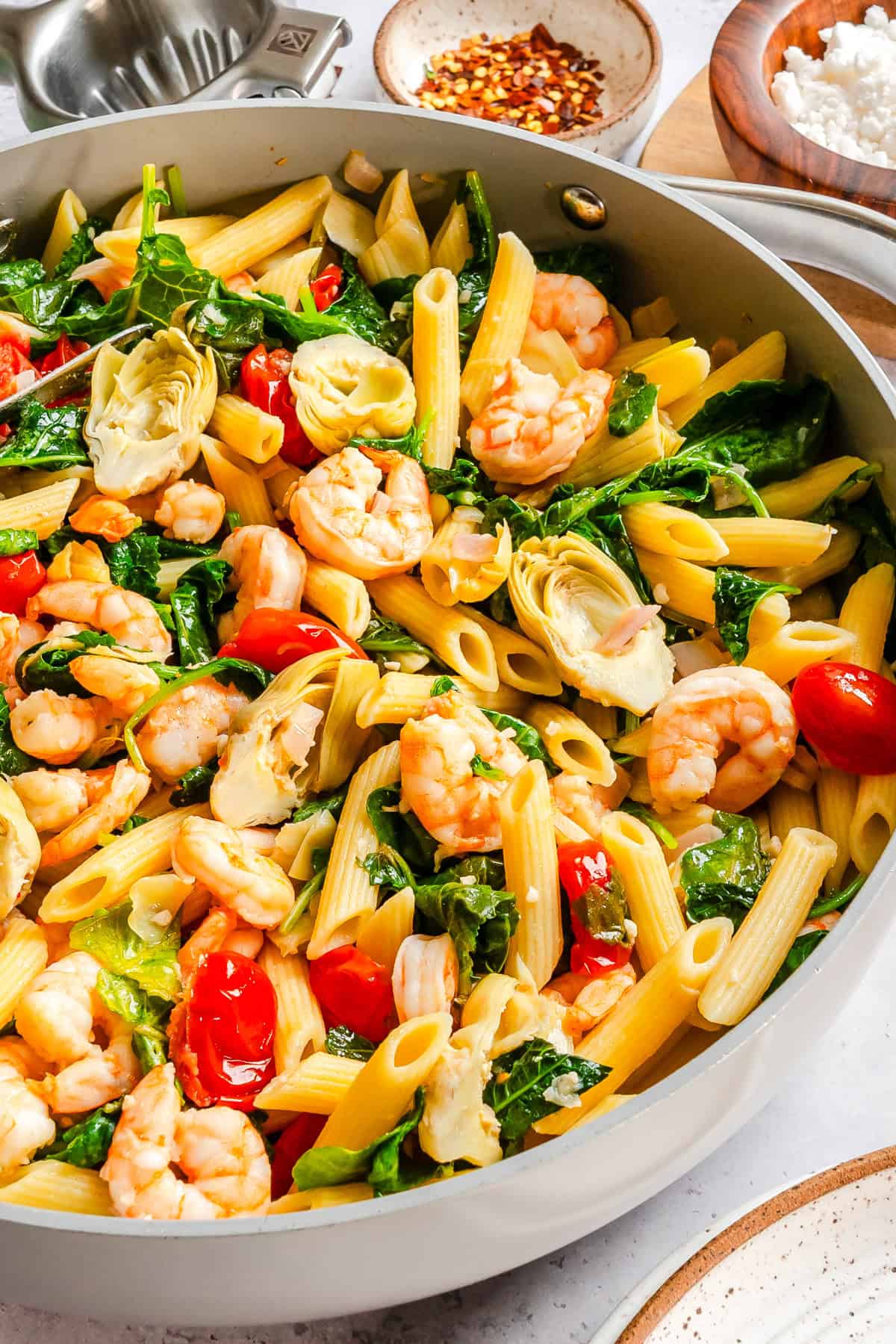 One skillet shrimp and kale pasta with artichoke hearts and cherry tomatoes in lemon olive oil sauce