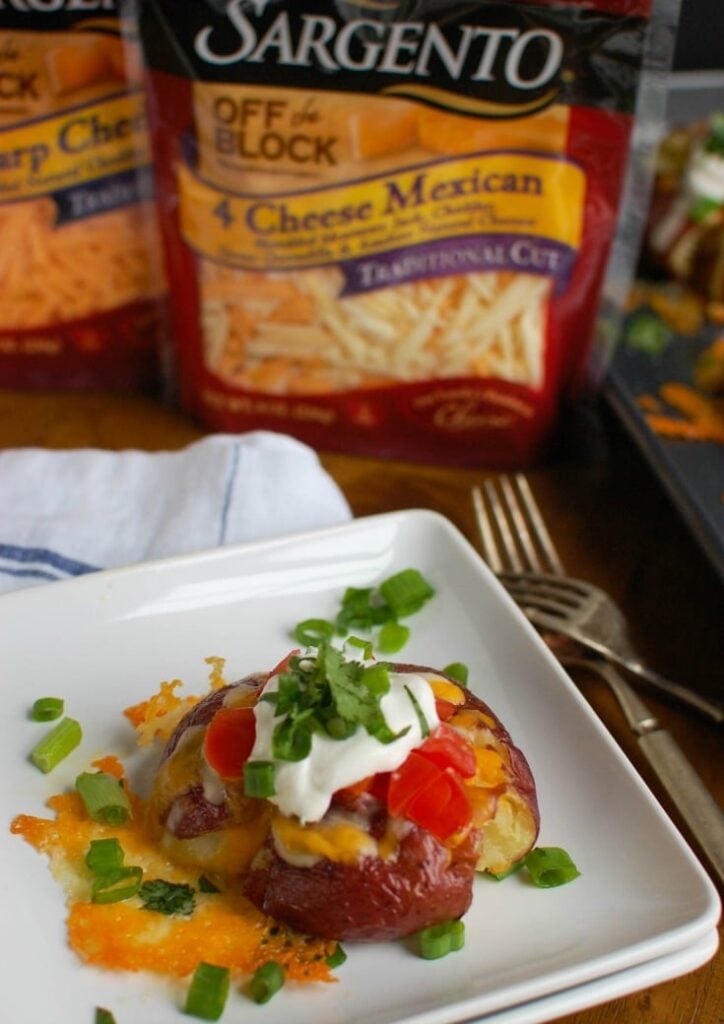 Loaded Smashed Potatoes are crispy on the outside and soft on the inside and loaded with cheese, sour cream, tomatoes, green onion and cilantro. These make an easy family meal or appetizer for game day or a party! 