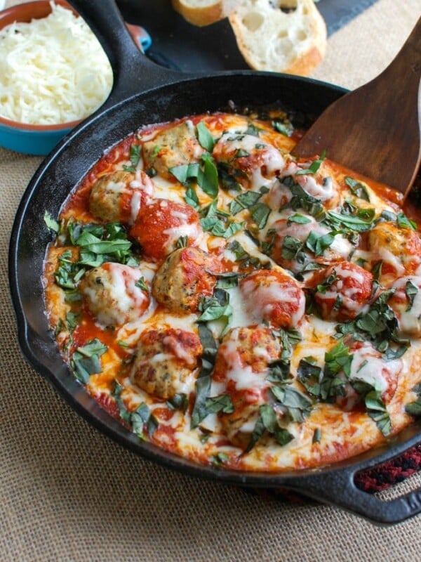 This Skillet Tomato Basil Meatballs is warm, cheesy and the perfect appetizer for a party, game day or for your family to enjoy. Tomato basil meatballs are cooked in a rich tomato sauce and topped with gooey, warm cheese and fresh basil. Pair it with warm baguette to create the perfect bite sized appetizer!