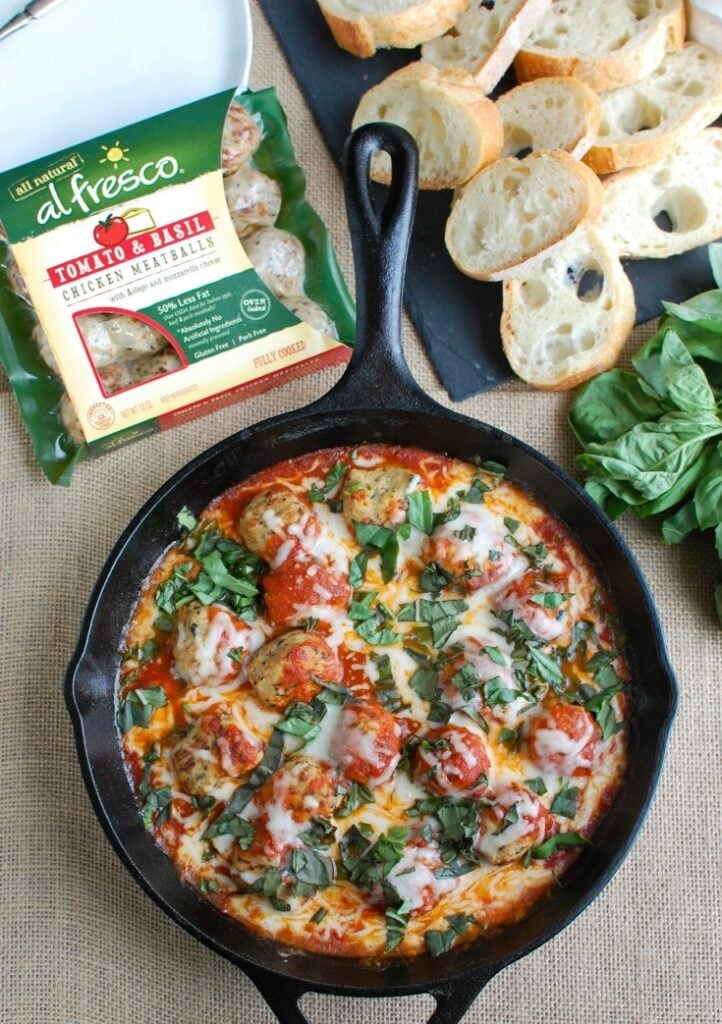 This Skillet Tomato Basil Meatballs is warm, cheesy and the perfect appetizer for a party, game day or for your family to enjoy. Tomato basil meatballs are cooked in a rich tomato sauce and topped with gooey, warm cheese and fresh basil. Pair it with warm baguette to create the perfect bite sized appetizer! 