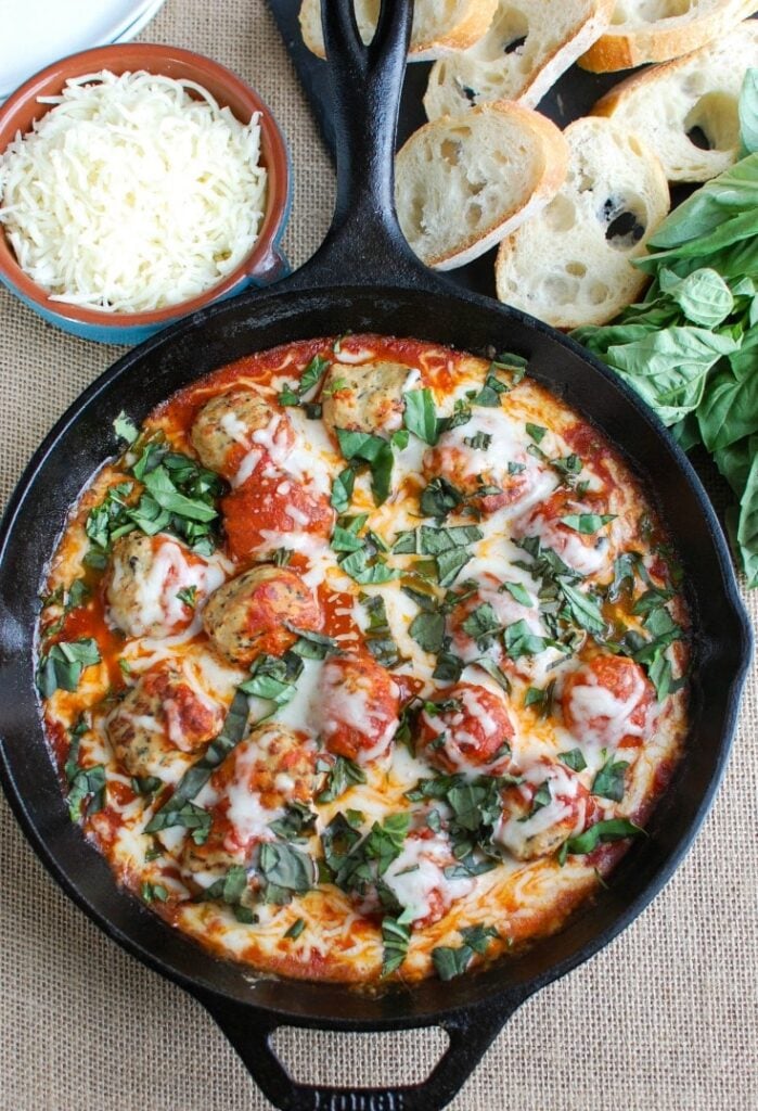 This Skillet Tomato Basil Meatballs is warm, cheesy and the perfect appetizer for a party, game day or for your family to enjoy. Tomato basil meatballs are cooked in a rich tomato sauce and topped with gooey, warm cheese and fresh basil. Pair it with warm baguette to create the perfect bite sized appetizer! 