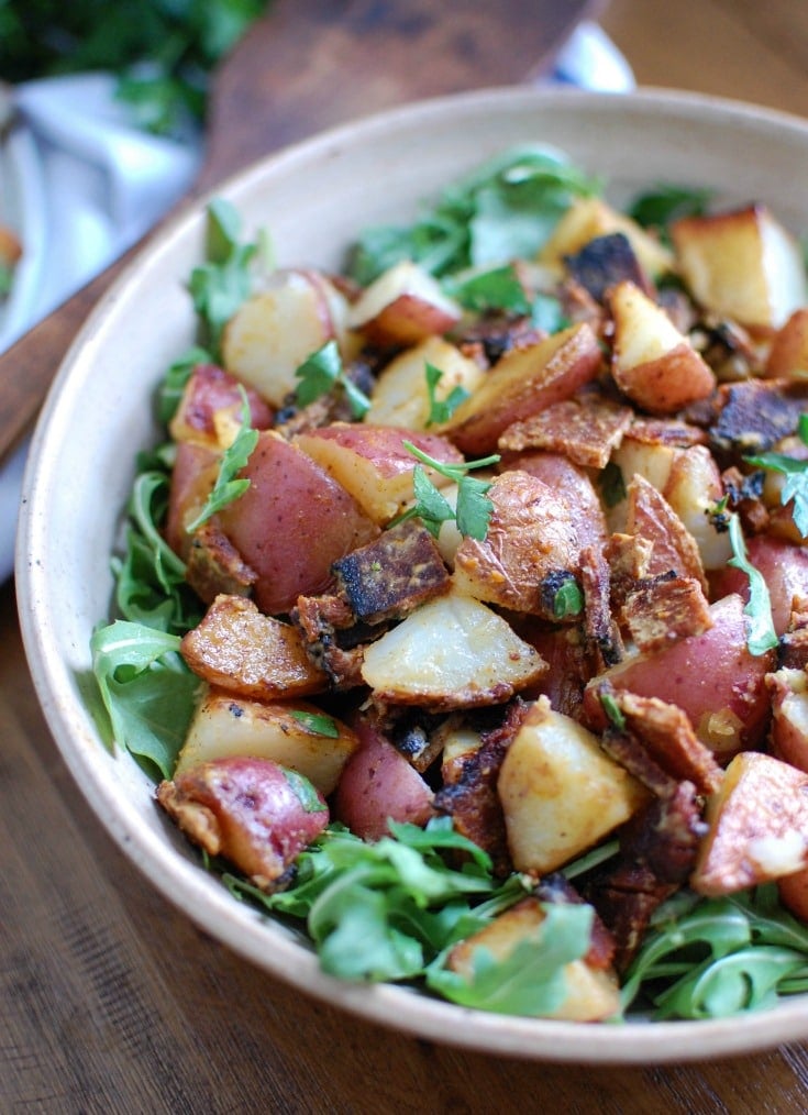 Warm, crispy potatoes are paired with crispy bacon, peppery arugula and is tossed in a mustard dressing in this Warm Potato Bacon Salad. This makes a hearty side dish or salad paired with your favorite meal.