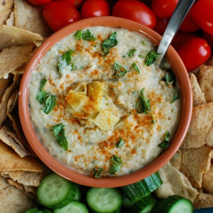 White Bean Artichoke Dip is a healthy appetizer, snack or spread for sandwiches. White beans, artichokes, lemon juice, olive oil, cayenne pepper, basil and garlic are blended and topped with fresh basil and parsley to create a healthy, flavorful dip.