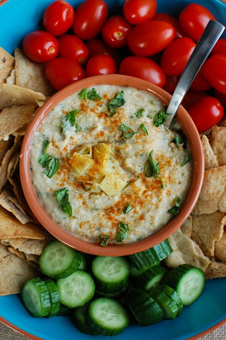 White Bean Artichoke Dip is a healthy appetizer, snack or spread for sandwiches. White beans, artichokes, lemon juice, olive oil, cayenne pepper, basil and garlic are blended and topped with fresh basil and parsley to create a healthy, flavorful dip.