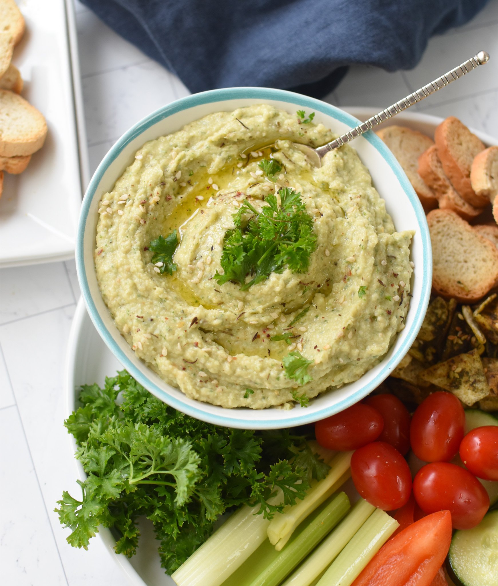 White Bean Artichoke Dip with crostini and veggies. 