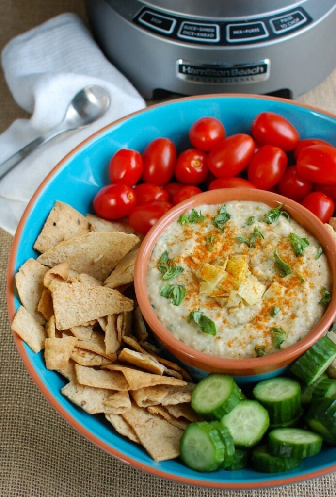 White Bean Artichoke Dip is a healthy appetizer, snack or spread for sandwiches. White beans, artichokes, lemon juice, olive oil, cayenne pepper, basil and garlic are blended and topped with fresh basil and parsley to create a healthy, flavorful dip.