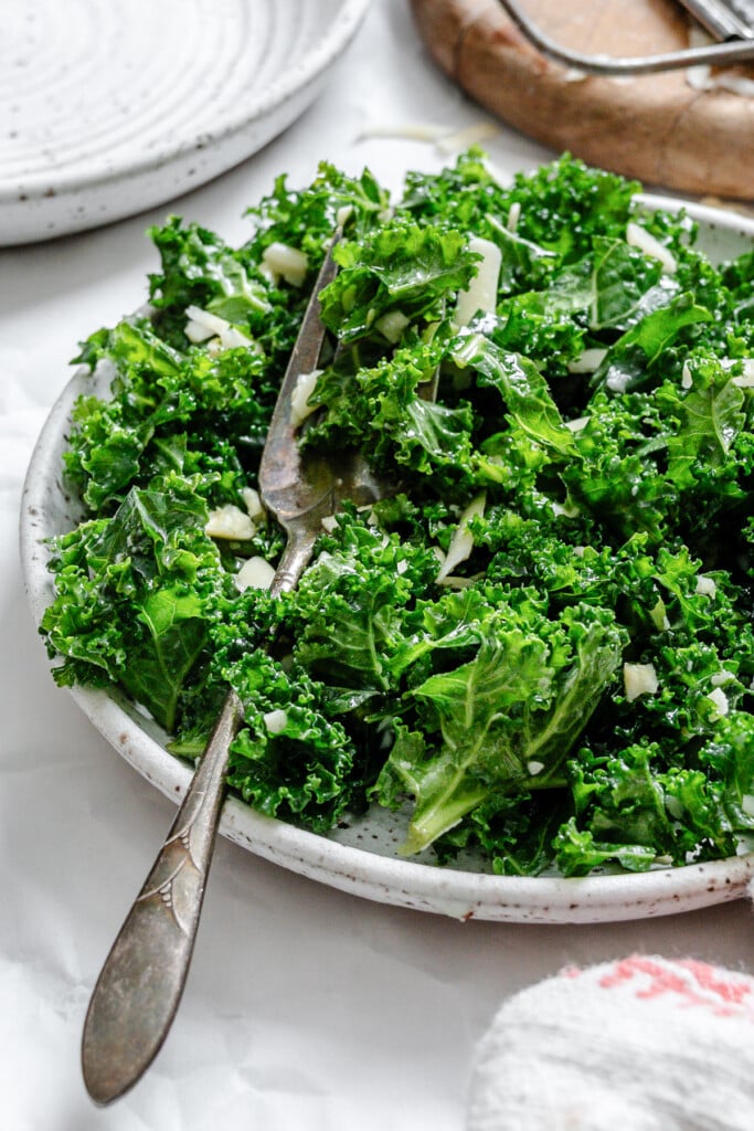 Kale Salad with Lemon Dressing with fork on a white plate