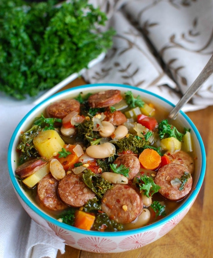 Slow Cooker Sausage Kale White Bean Soup is hearty and packed with protein and vitamins. This soup simmers in your slow cooker while you go about your day, leaving you with the perfect dinner for your family. 