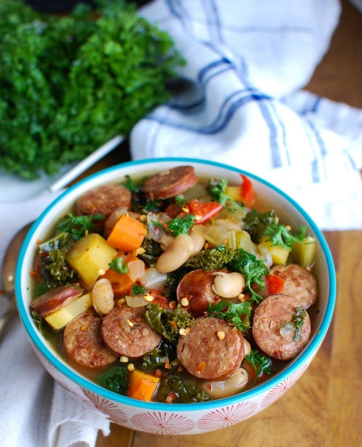 Slow Cooker Sausage Kale White Bean Soup is hearty and packed with protein and vitamins. This soup simmers in your slow cooker while you go about your day, leaving you with the perfect dinner for your family.