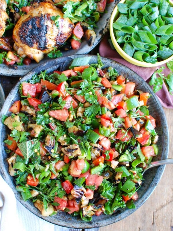 Mediterranean Eggplant Salad mixes grilled eggplant with fresh tomatoes, mint, parsley, green onion, bell pepper and tossed with olive oil, lemon juice, za'atar and crushed red pepper. This is the perfect side salad for a summer BBQ or party or to pair with grilled chicken or fish. 