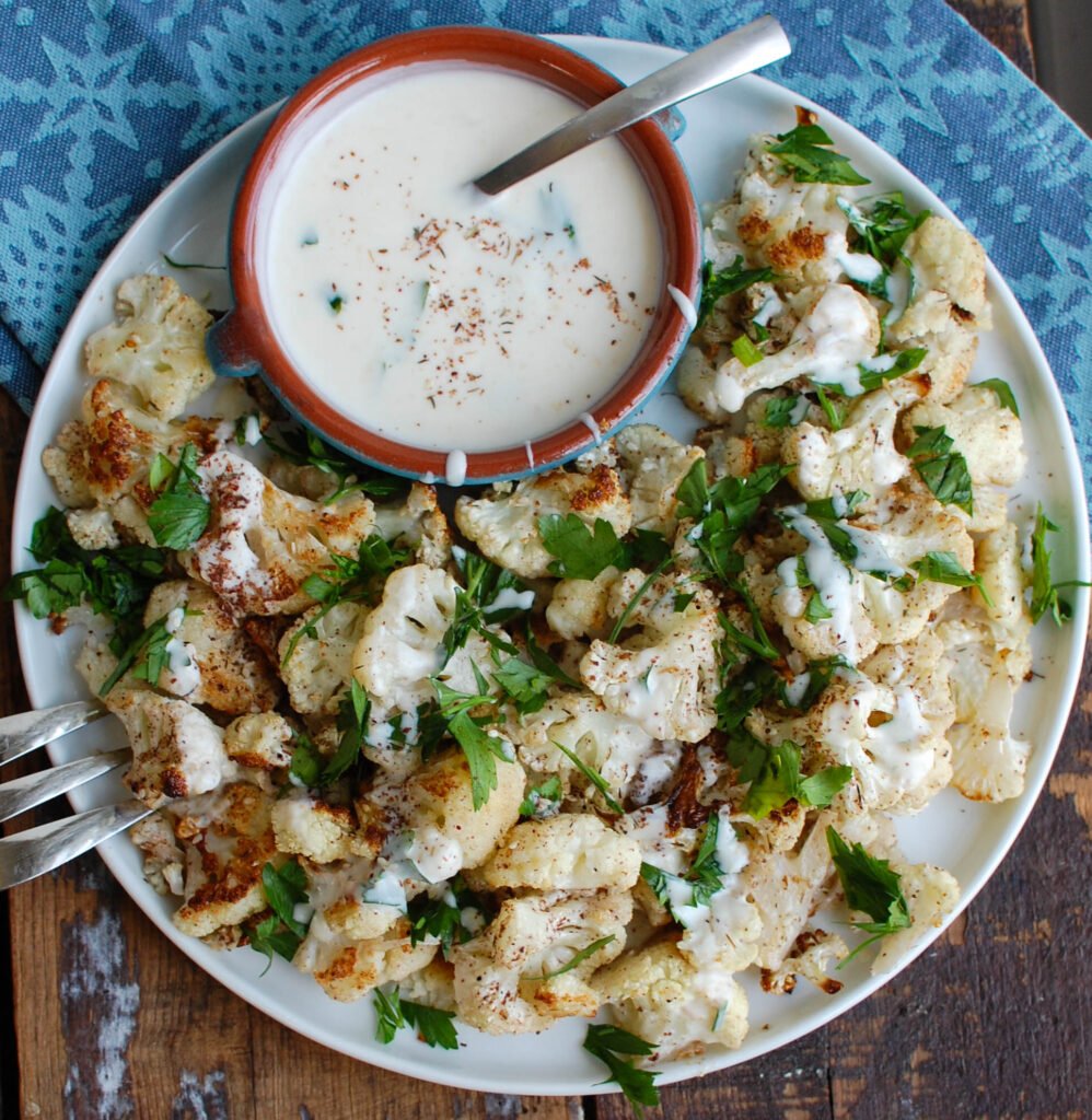 Za'atar Roasted Cauliflower with Yogurt Tahini Sauce takes your normal roasted cauliflower to a new level. Earthy and slightly sweet the za'atar is the perfect spice to add to your roasted cauliflower and is complimented nicely by the yogurt tahini sauce. 