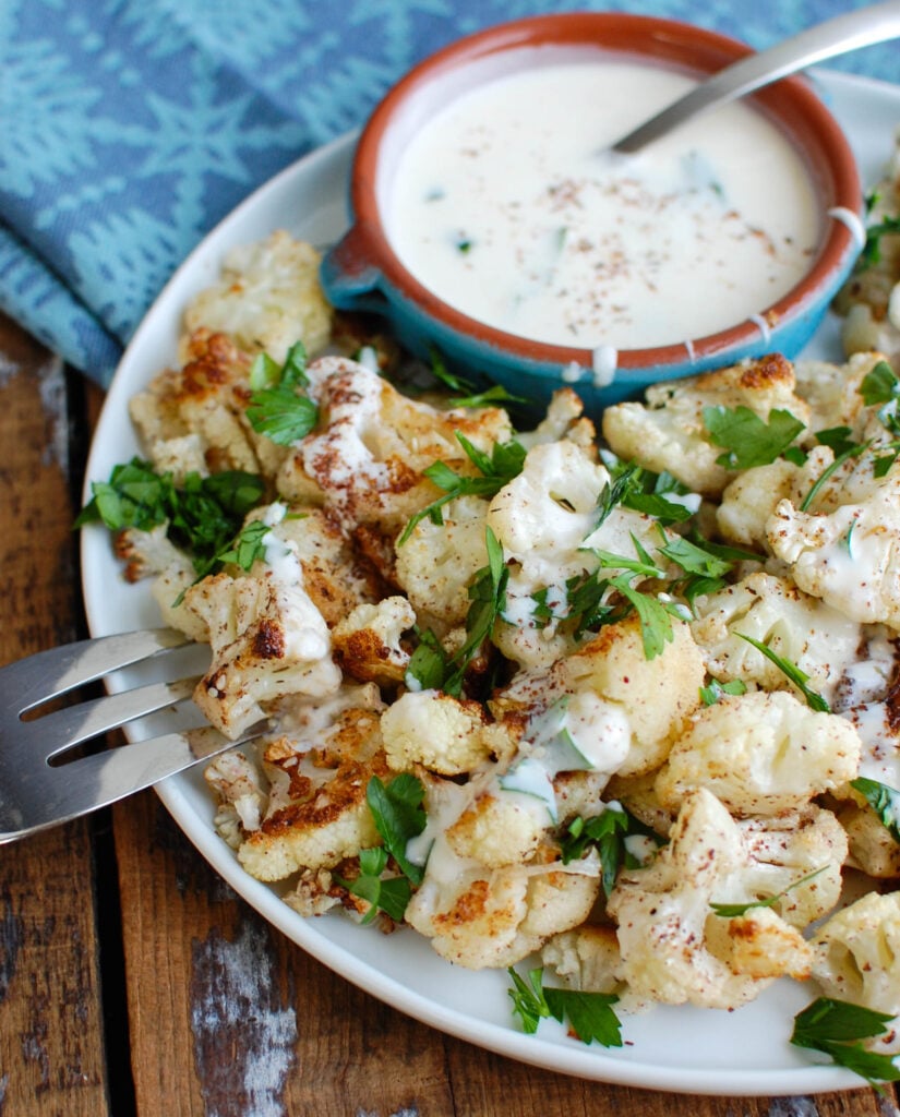 Za'atar Roasted Cauliflower with Yogurt Tahini Sauce takes your normal roasted cauliflower to a new level. Earthy and slightly sweet the za'atar is the perfect spice to add to your roasted cauliflower and is complimented nicely by the yogurt tahini sauce. 