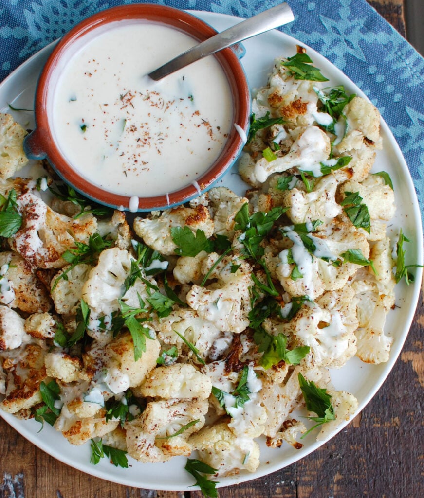 Za'atar Roasted Cauliflower with Yogurt Tahini Sauce takes your normal roasted cauliflower to a new level. Earthy and slightly sweet the za'atar is the perfect spice to add to your roasted cauliflower and is complimented nicely by the yogurt tahini sauce.