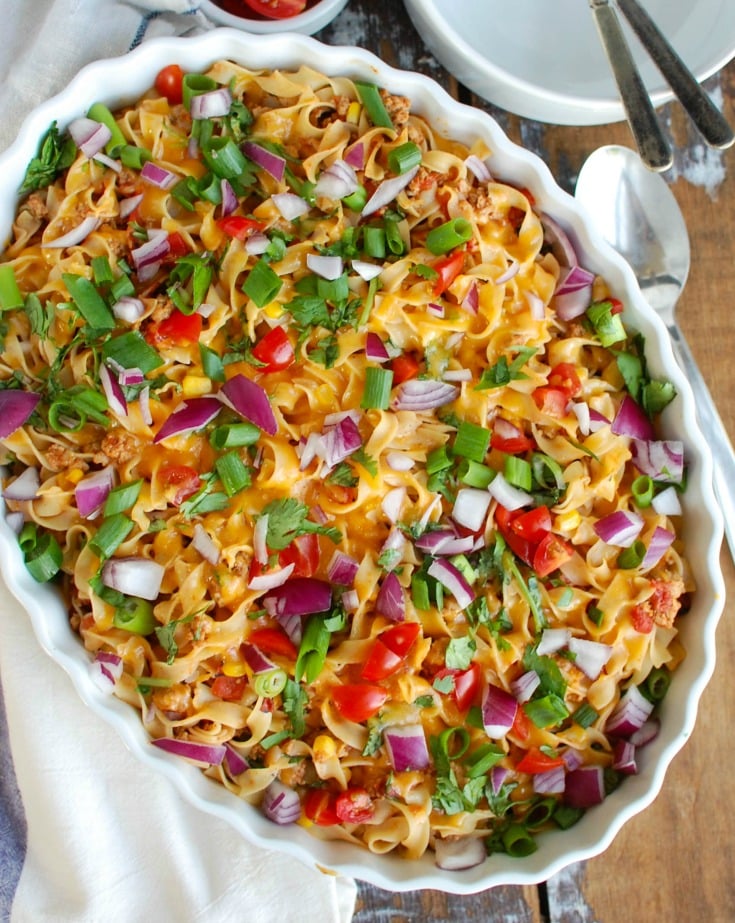 Easy Mexican Noodle Casserole makes weeknight meals easy, fun and festive with a colorful casserole packed with No Yolk Noodles,  colorful vegetables, ground turkey, spices and cheese. This dish will quickly become a family favorite. 