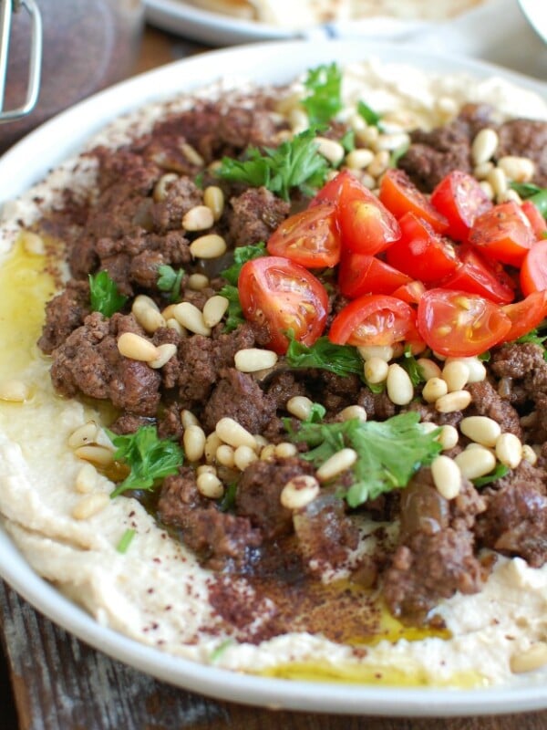 Hummus with Spiced Beef and Toasted Pine Nuts is an easy appetizer, lunch or dinner featuring creamy hummus topped with warm, spiced beef, toasted pine nuts, freshly chopped tomatoes and parsley. It is gluten-free and full of protein. 