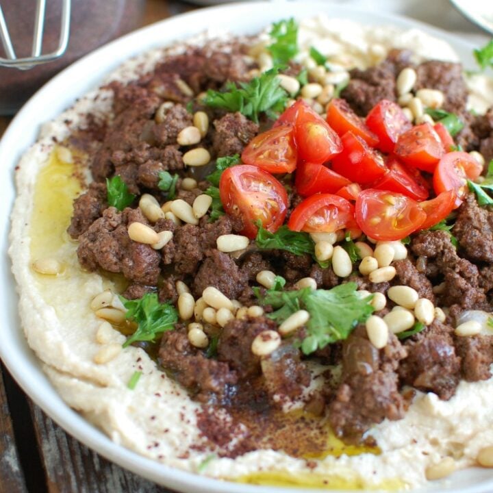 Hummus with Spiced Beef and Toasted Pine Nuts is an easy appetizer, lunch or dinner featuring creamy hummus topped with warm, spiced beef, toasted pine nuts, freshly chopped tomatoes and parsley. It is gluten-free and full of protein.