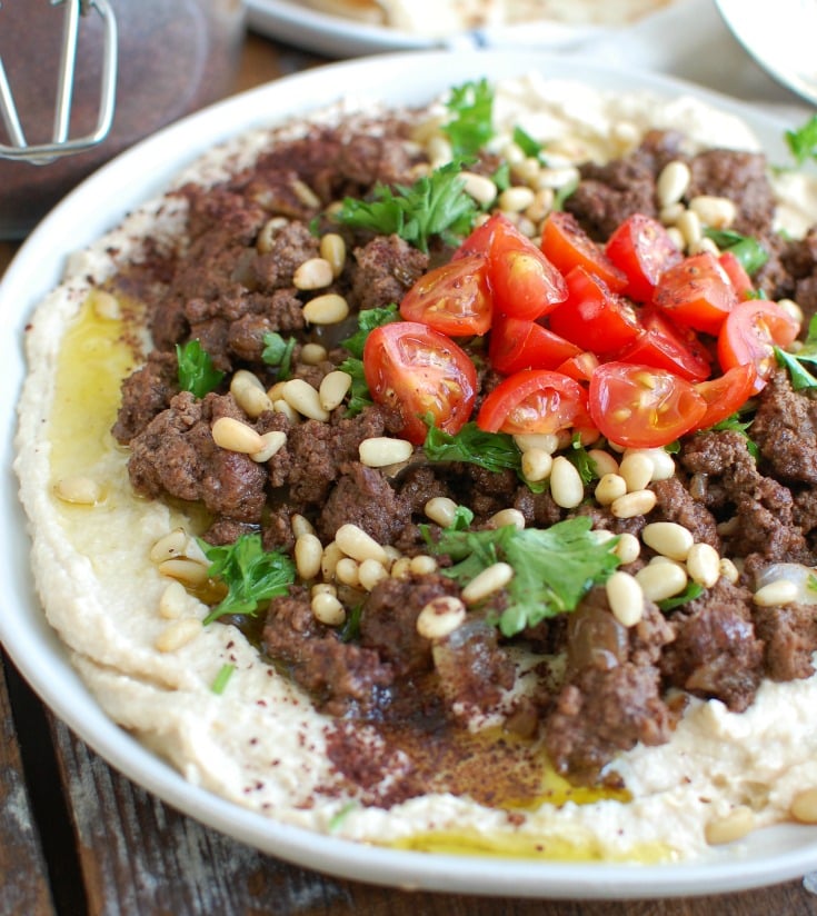 Hummus with Spiced Beef and Toasted Pine Nuts is an easy appetizer, lunch or dinner featuring creamy hummus topped with warm, spiced beef, toasted pine nuts, freshly chopped tomatoes and parsley. It is gluten-free and full of protein. 