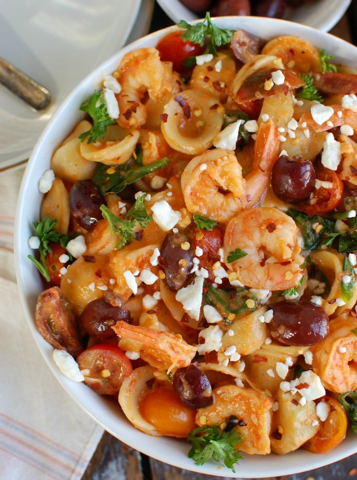  One Pot Mediterranean Shrimp Pasta is an easy one pot meal mixing shrimp with your favorite Mediterranean ingredients, pasta and a creamy roasted red pepper sauce. Shrimp pairs nicely with the fresh tomatoes, artichokes, kalamata olives, spinach and is topped with a creamy roasted red pepper sauce.  