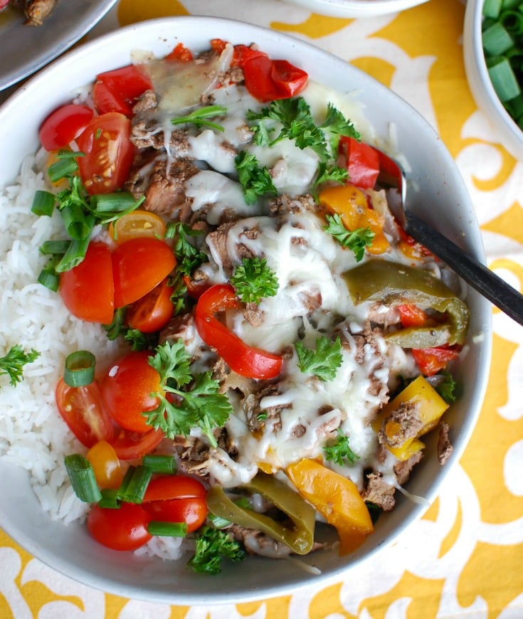 If you like philly cheesesteaks you will love this lighter take created with your slow cooker. Slow Cooker Philly Cheesesteak Rice Bowls features slow cooker beef cooked in a delicious marinade placed on top of a bed of rice with melted provolone cheese and your favorite toppings. 