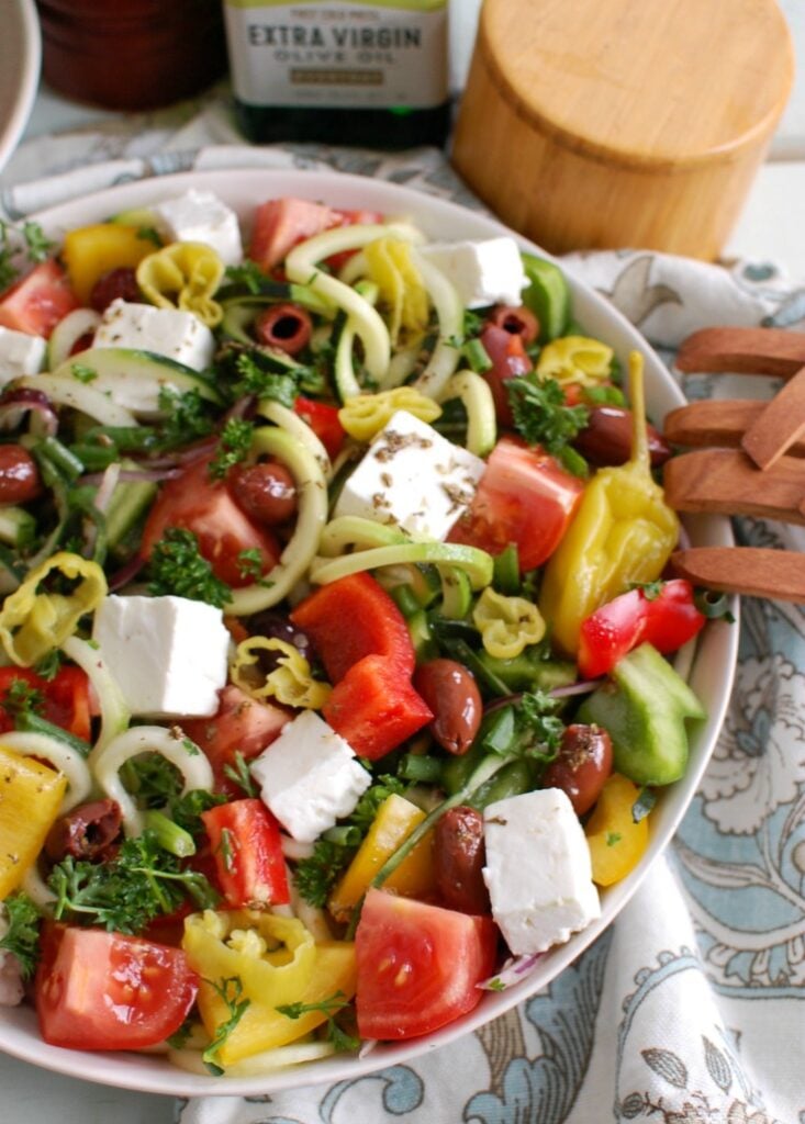 Spiralized Greek Style Salad with wooden tongs