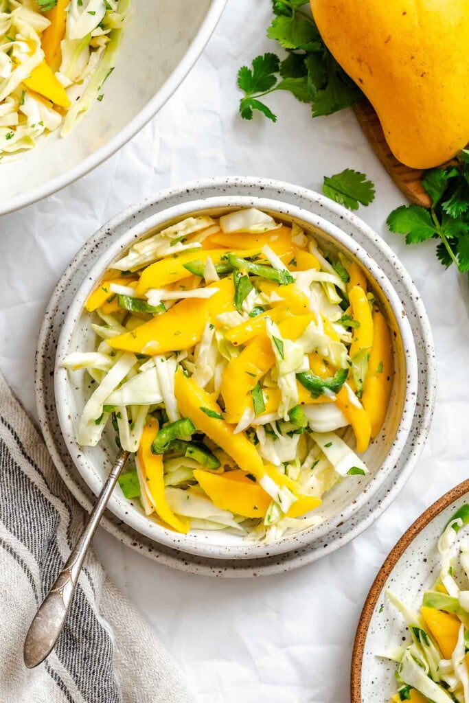 Easy Mango Cabbage Coleslaw with fork in bowl 