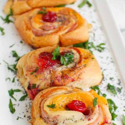 Ham Cheese and Cranberry Rollups on white platter